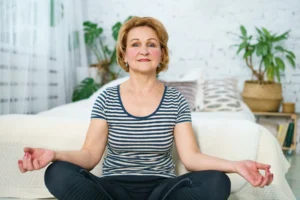 mature-woman-in-lotus-position-at-home-on-mat-2024-12-02-07-29-20-utc